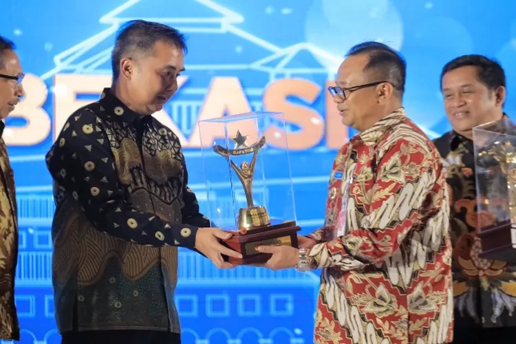 Pj Gubernur Jawa Barat, Bey Machmudin menyerahkan penghargaan kepada Pj Wali Kota Bekasi, R Gani Muhamad (Humas Kota Bekasi)