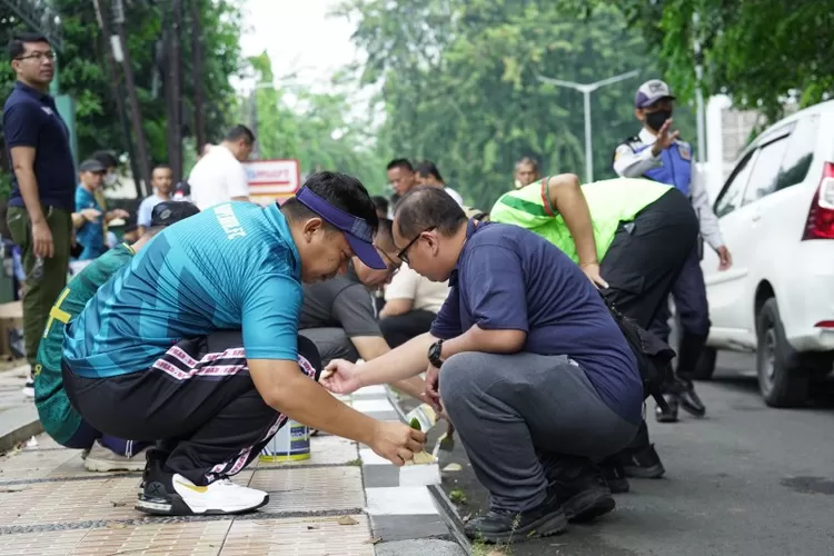 Pj Wali Kota Bekasi R Gani Muhamad (kanan) tengah mengecat trotoar 
