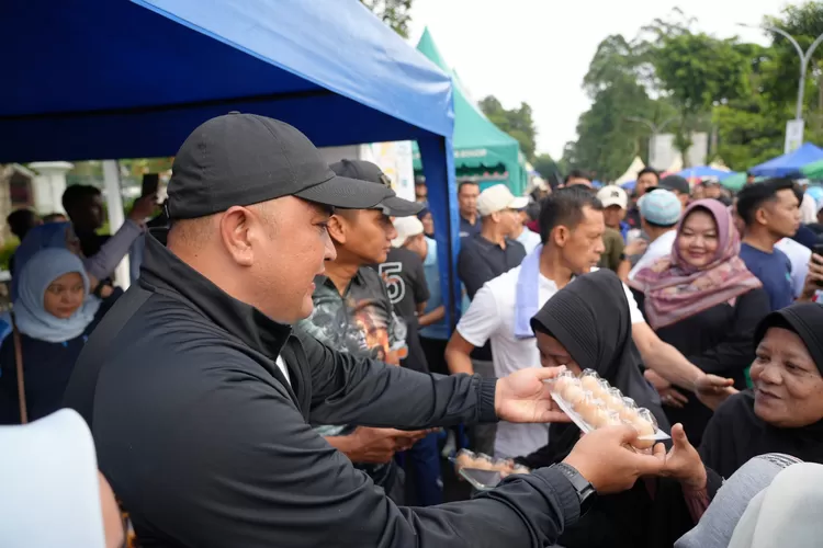 Bupati Bogor Rudy Susmanto membagikan paket telur kepada warga pada Gerakan Makan Telur di CFD Tegar Beriman, Minggu (23/11/2025).