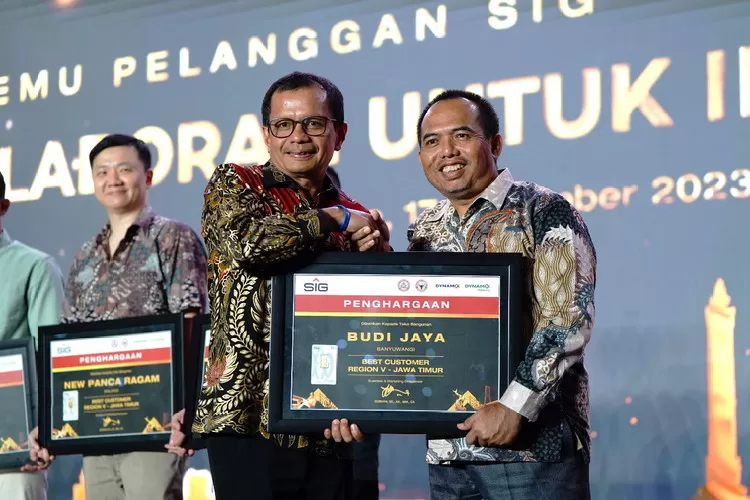 Direktur Utama SIG, Donny Arsal (kiri) memberikan penghargaan Best Customer kepada pemilik Toko Bangunan Budi Jaya