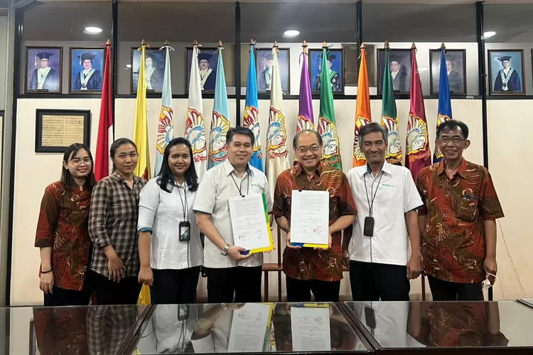 Kepala Kantor Cabang BPJS Ketenagakerjaan Surabaya Darmo, Imron Fatoni dan Rektor UKWMS, Kuncoro (tengah) usai penandatanganan kesepakatan