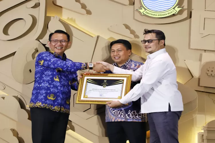 Penghargaan dari Komisi Informasi diserahkan Komisioner Komisi Informasi Jawa Barat Husni Farhani Mubarak kepada Pj Bupati Bekasi Dani Ramdan, di acara IKP Fest 2023 di Hotel Holiday Inn Jababeka. (istimewa )