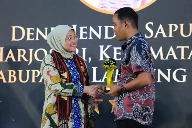 Deni Hendri Saputra (kanan) menerima penghargaan dari Menaker Ida Fauziyah (kiri). 