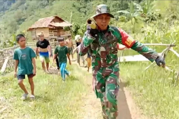 Serda Suryanto Babinsa Desa Ulumanda Koramil 1404 04 Malunda, Sulawesi Barat membantu proses evakuasi dengan tandu (sebatang bambu dan kain sarung) salah seorang warga di wilayah binaannya. Foto: Puspen TNI