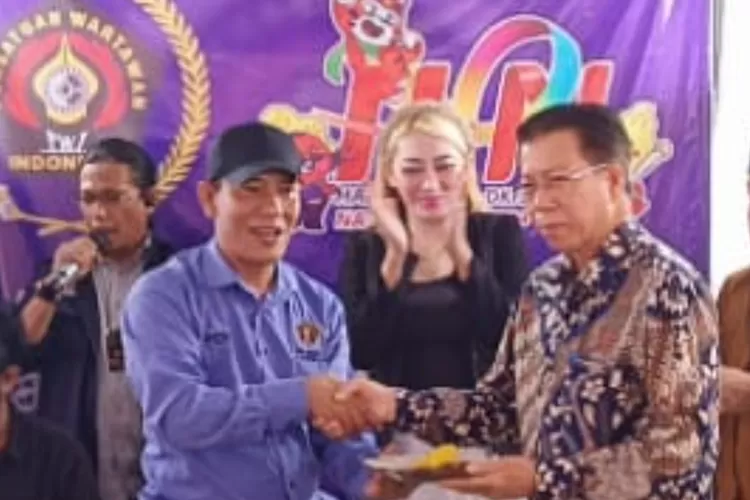Ketua PWI Kota Depok Rusdy Nurdiansyah menyerahkan tumpeng ke Kadiskominfo Manto (Ist)