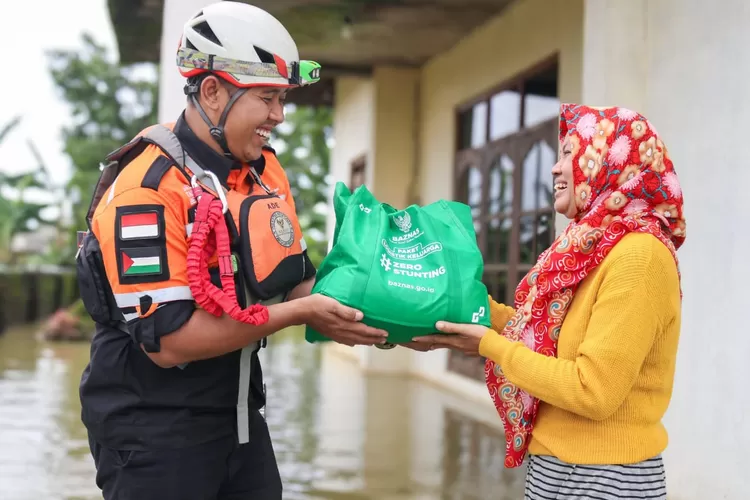Salah seorang korban banjir di Kudus  menerima bantuan dari BTB  (Baznas Tanggab Bencana) di tempat pengungsian.