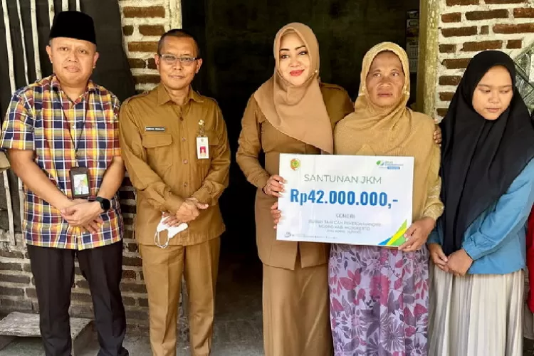 Bupati Mojokerto (tengah) bersama BPJS Ketenagakerjaan saat menyerahkan manfaat program JKM kepada ahli waris buruh tani