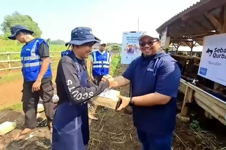 Vice President Operasional Human Initiative, Romi Ardiansyah, di salah satu kandang hewan qurban di Bekasi, Jawa Barat (17/6/ 2024), menyerahkan besek berisi daging kurban untuk didistribusikan kepada penerima manfaat..
