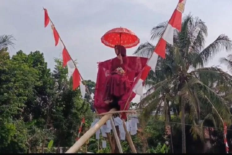 Seorang janda muda yang disiapkan sebagai hadiah utama lomba panjat pinang. (TOPMedia.co.id / Istimewa)