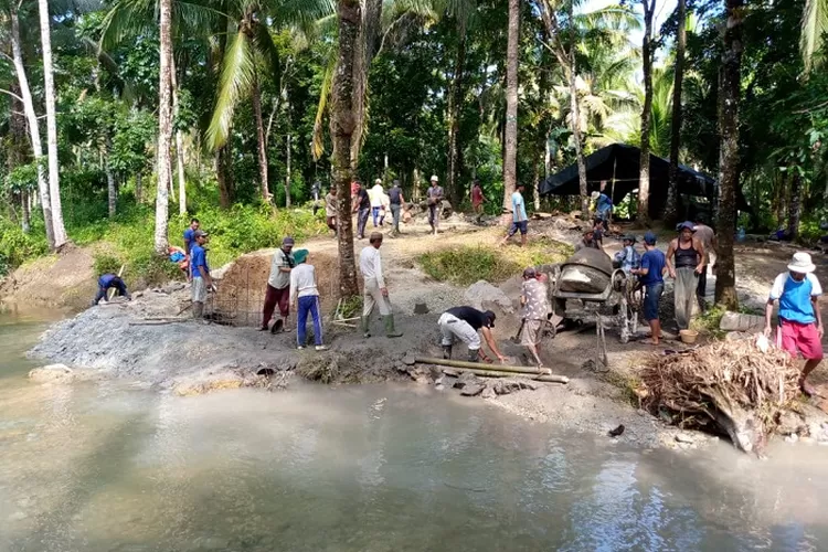 Warga di Desa Manglid, Kecamatan Cibitung, Kabupaten Pandeglang, secara swadaya membangun jembatan di atas Kali Cibuluh yang menghubungkan Kampung Rancawalang dan Palawijo, Selasa (29/4/2025)