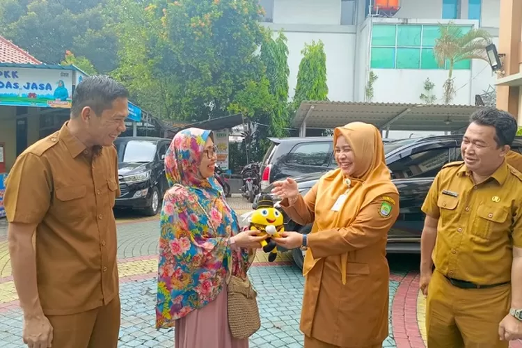 Kepala UPT Samsat Cikokol Awal Pasenggong bersama jajarannya memberikan cindera mata kepada masyarakat yang taat bayar pajak