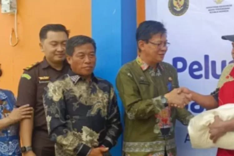 Pj Sekda Sarwo Mintarjo menyerahkan bantuan pangan bagi masyarakat berpenghasilan rendah, yang digelar di halaman Gudang Bulog Puruk Cahu, Kamis (13/11/2025)