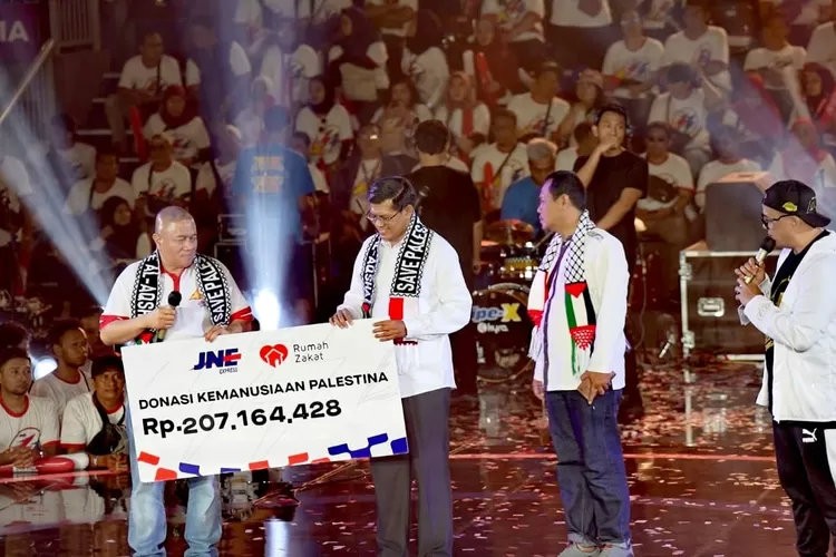 Penyerahan donasi kemanusiaan dari karyawan JNE untuk Palestina diserahkan oleh M Feriadi Soeprapto, Presiden Direktur JNE (Kiri) kepada Irvan Nugraha Selaku CEO Rumah Zakat (kanan) dalam puncak HUT JNE ke-33 di GOR Britama Jakarta, Minggu (26/11/2023).  (Istimewa)