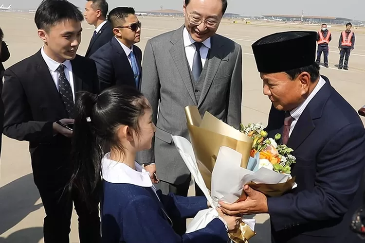 Prabowo Subianto mendapat bunga dari seorang bocah saat tiba di bandara dalam kunjungannya ke China. (Tim Prabowo)
