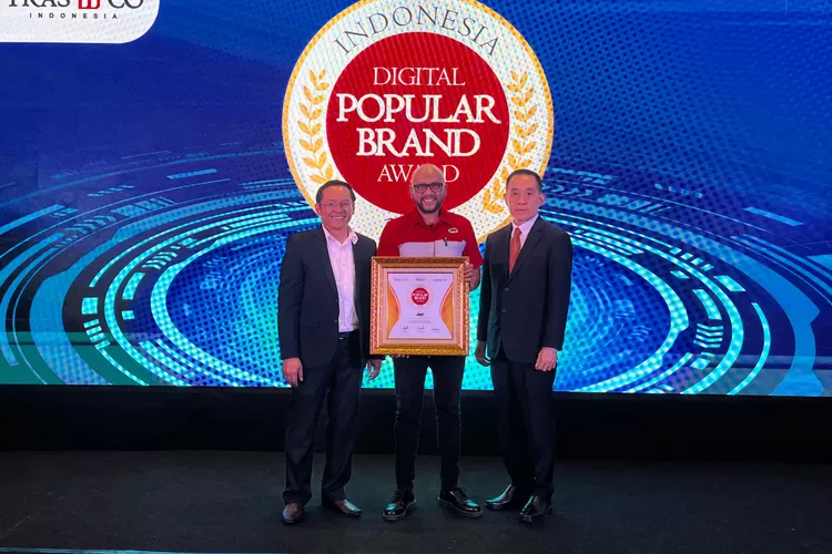  Yance Arvan, Marketing Project Senior Analyst JNE mewakili penerimaan penghargaan Indonesia Digital Popular Brand Award 2024, yang diserahkan Tri Raharjo, CEO Tras N CO Indonesia-Chairman IBC (kiri) dan Alex Iskandar selaku Direktur IMFocus Digital Marketing (kanan). (Foto: Dok. Istimewa)