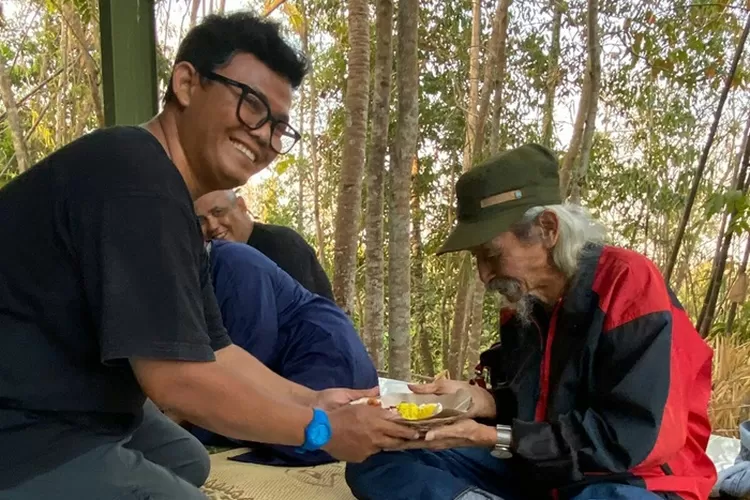 Penyerahan tumpung dari Deden kepada Potongan tumpeng diserahkan kepada Untung Basuki musisi gaek pada tasyakuran rumah baru Sanggar Bambu.  (Teguh Priyono)
