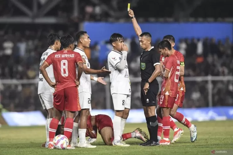 Wasit Eko Agus Sugiharto (kedua kanan) memberikan kartu kuning kepada pesepak bola Sulawesi Tengah Ichansyah (ketiga kiri) saat melawan tim Aceh pada pertandingan babak 8 besar PON XXI Aceh-Sumut 2024 di Stadion H Dimurthala, Banda Aceh, Aceh, Sabtu (14/9/2024).  (ANTARA FOTO/Adeng Bustomi)