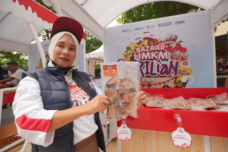 Ebi Sulastri, menunjukkan produk ikan asap khas dari Kabupaten Bulukumba Sulawesi Selatan.  (Foto: Dok. BRI)
