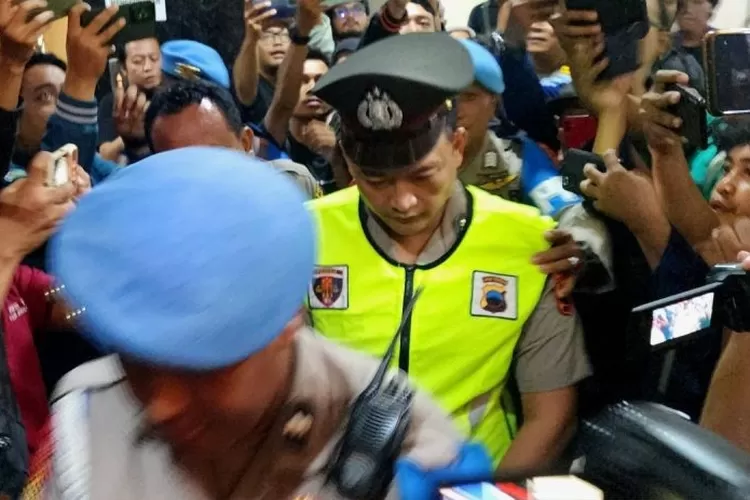 Anggota Polrestabes Semarang Aipda R, terduga pelaku penembakan siswa SMKN 4 Kota Semarang, GRO, saat memasuki ruang sidang Bidang Propam Polda Jawa Tengah di Semarang, Senin (9/12/2024). ( ANTARA/I.C. Senjaya)