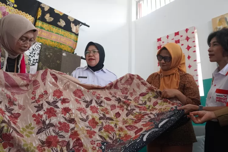 Menteri PPPA RI, Arifah Fauzi (kiri) dan Direktur - CEO XL Axiata, Dian Siswarini (dua dari kanan) mengamati hasil batik warga binaan perempuan di Lapas Perempuan Kelas IIB Yogyakarta, Wonosari, Gunungkidul, Senin (24/2/2025), yang diberdayakan melalui program pemberdayaan perempuan, Sisternet.  (Foto: Dok. XL Axiata)