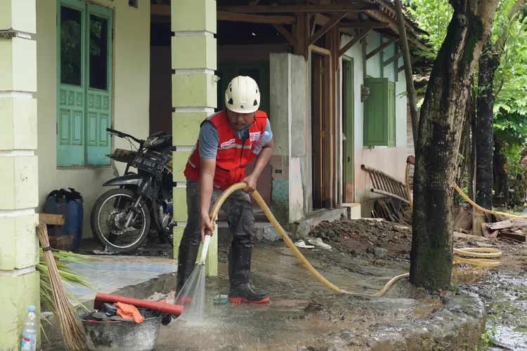 Personel relawan PMI DIY melakukan pembersihan lokasi terdampak bencana hidrometeorologi banjir di Bantul dan Kulon Progo.  (Foto: Dok. Humas PMI DIY)