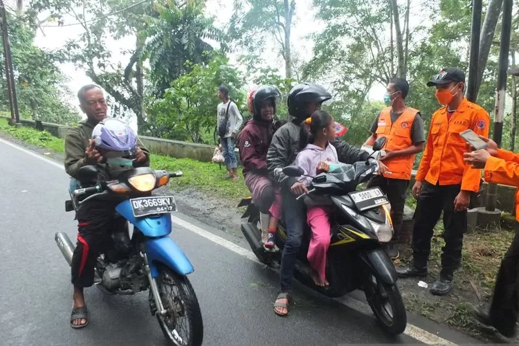 Tim BPBD Jember saat membagi-bagikan masker kepada pengendara di kawasan Gunung Gumitir, perbatasan Kabupaten Jember-Banyuwangi setelah erupsi Gunung Raung, Jumat (13/6/2025).  (ANTARA/Hamka Agung)