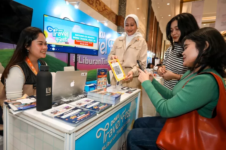 Co-Founder dan Chief Marketing Officer DOKU, Himelda Renuat (tengah) turut melayani pengunjung menggunakan QRIS di booth DOKU Travel Fest, berbarengan dengan KAI EXPO pada 2-3 Agustus 2025. Dengan semangat 'Healing Tetap Jalan, Pakai Promo Andalan' DOKU siap meluncurkan DTF 9.9 secara online besok. (Foto: Dok. Istimewa)