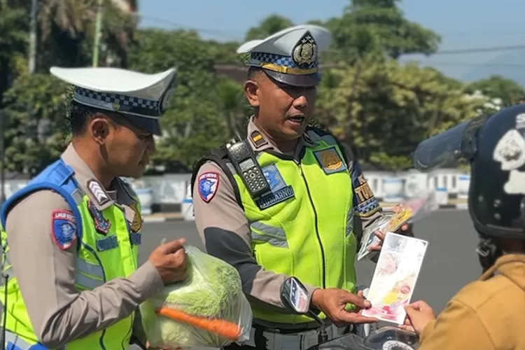 Polisi Satlantas Polres Salatiga bagi sayur kepada pengendara.   (Edy Susanto HM)