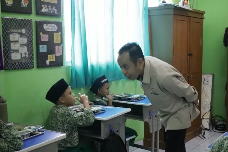 Wakil Ketua KPAI Jasra Putra berinteraksi dengan salah satu siswa penerima manfaat Program Makan Bergizi Gratis (MBG).  (ANTARA/HO-KPAI )
