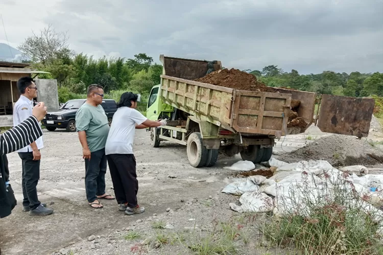 Petugas DLH Boyolali Bersama Anggota Polsek Cepogo mengubur puluhan karung limbah ayam di Jalur Solo-Selo-Borobudur (SSB) (Foto: Mulyawan)