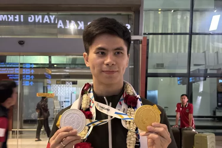Atlet wushu Indonesia Edgar Xavier Marvelo menunjukkan medali SEA Games 2025 saat ditemui di Bandara Soekarno-Hatta, Tangerang, Selasa (17/12/2025).  (ANTARA/Fajar Satriyo)