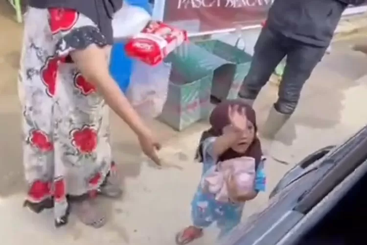 Tangkapan layar seorang bocah yang dengan gembira menerima bantuan makanan dan pakaian di tengah suasana pengungsian banjir Aceh Tamiang.  (TikTok/zaits_bf)