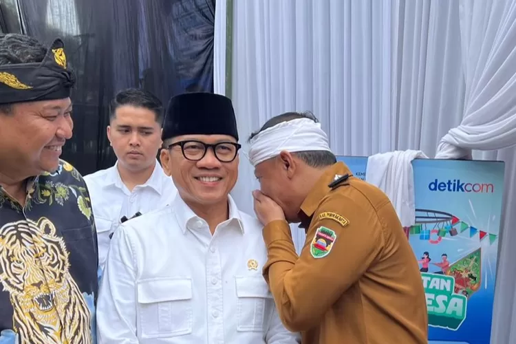 Ketua Umum APDESI, Asep Anwar Sadat, SH, (kanan) tengah berbisik di sela-sela acara Hari Desa Nasional 2025 di Desa Cisaat, Subang (Selasa, 14/1). (Istimewa)