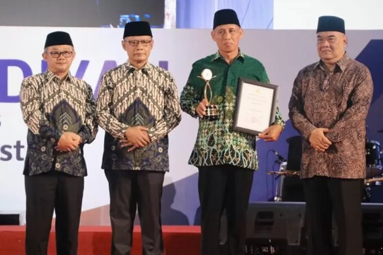 Mukardi saat menerima piala dan penghargaan Muhammadiyah Award pada puncak peringatan Milad PP Muhammadiyah ke 111