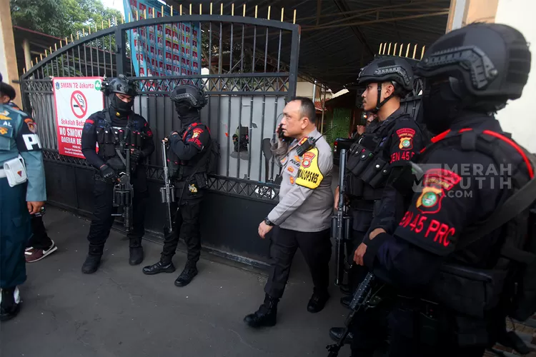 Petugas kepolisian berjaga di depan SMAN 72 Jakarta pascaledakan. (HukamaNews.com / Net)