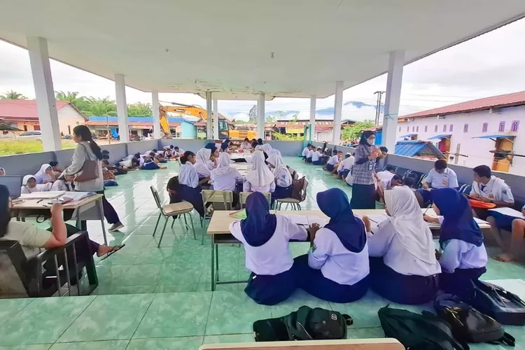 Siswa-siswi SMP di Morut terpaksa menggunakan balai dusun untuk belajar karena sekolah mereka terendam banjir. (Foto: Ist).