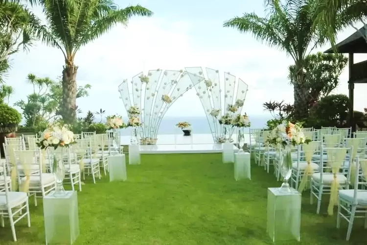 Pernikahan di pantai tetap sakral meski di luar ruangan dengan dekorasi pernikahan bergaya pelaminan minimalis. (the stone uluwatu)