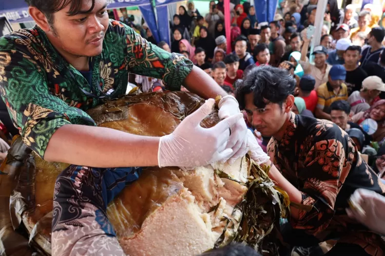 BAGIKAN : Panitia Lopis Raksasa saat memotong dan membagikan lopis kepada masyarakat yang datang ke daerah Krapyak, untuk mencicipi makanan tersebut.