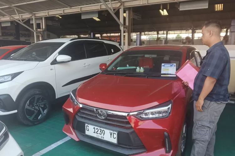 CEK MOBIL : Kuasa hukum Rindiani, Didik Pramono saat mengecek mobil Toyoya Agya merah milik kliennya di bengkel dan dealer resmi Nasmoco Pekalongan. (KONTENJATENG.COM/Arif Prayoga)