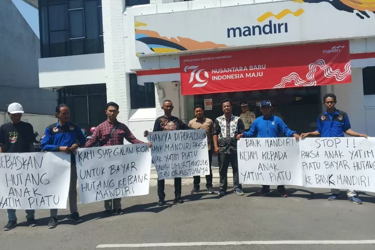 AKSI : Tim LBH Adhyaksa didampingi LSM Robin Hood 23 menggelar aksi damai di halaman KCP Bank Mandiri Hayam Wuruk, dengan membentangkan sejumlah poster sebagai bentuk dukungan kepada anak yatim yang rumahnya terancam dilelang bank. (KONTENJATENG.COM/Arif Prayoga)