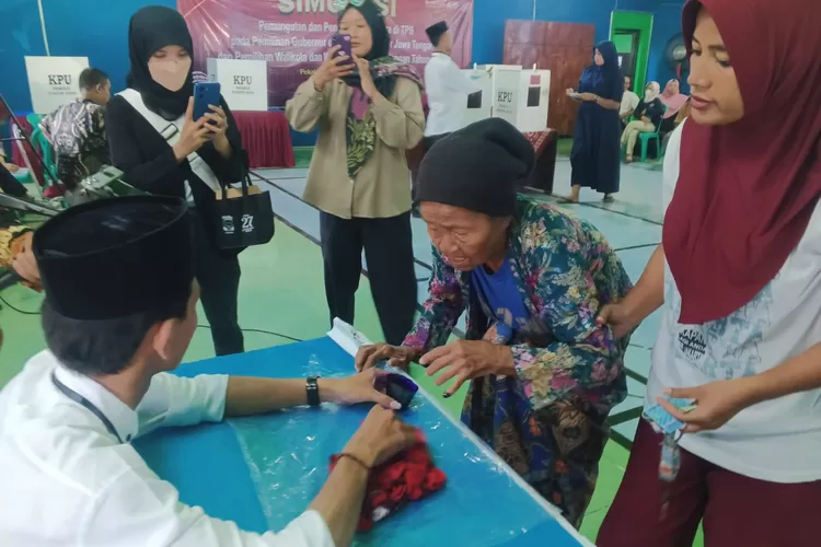 LANSIA : Salah satu pemilih Lansia didampingi pihak keluarga, usai menggunakan hak pilihnya pada saat simulasi pemungutan suara di aula Kelurahan Kalibaros. (KONTENJATENG.COM/Arif Prayoga)