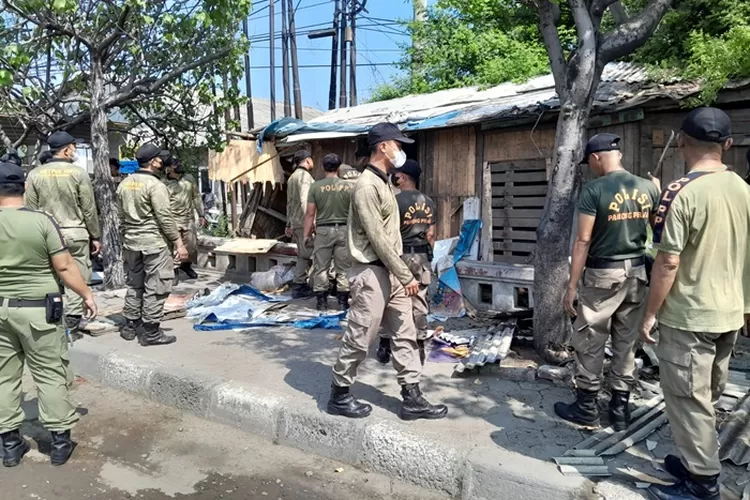 Petugas Satpol PP saat membantu DPU untuk membersihkan PKL liar di atas selokan.  (Ayosemarang.com/ Audrian Firhannusa)