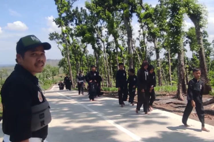 Anggota PSHT Patean berjalan kaki menyusuri jalan Sojomerto kalices Minggu 3 Desember 2023. (Kontributor Kendal Edi Prayitno)