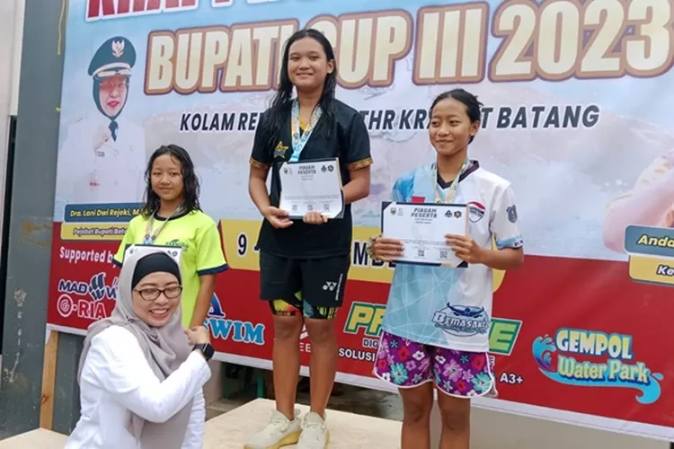 Pj Bupati Batang Lani Dwi Rejeki mengalungkan mendali jura Lomba renang Krapprov dan Taruna Bupati Cup III 2023.  (Muslihun/Kontributor Batang )