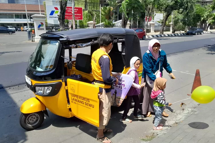 Rina Rahayu bersama anak-anaknya usai naik bajaj kuning di Semarang. Bajaj ini bisa dinaiki secara gratis.  ((Ayosemarang.com/ Audrian Firhannusa))