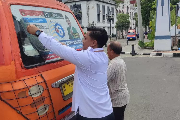 Bawaslu Semarang saat melepas stiker kampanye yang melanggar aturan.  ((Bawaslu))