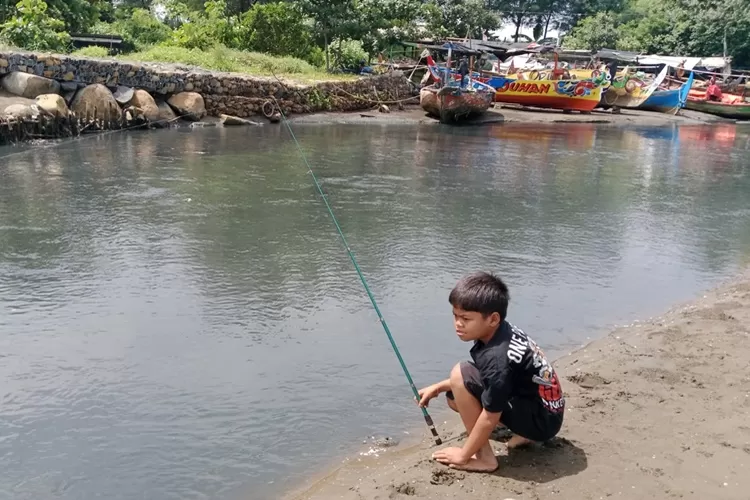 Seorang anak memancing muara Sungai Sono Pantai Sigandu yang mengalami pencemaran (Muslihun/Kontributor Batang)