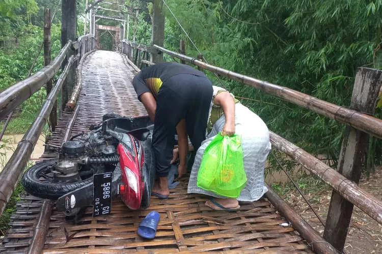 Pengendara motor tergelincir saat melintas, di jembatan kayu Sungai Blorong. (Edi Prayitno/kontributor Kendal)