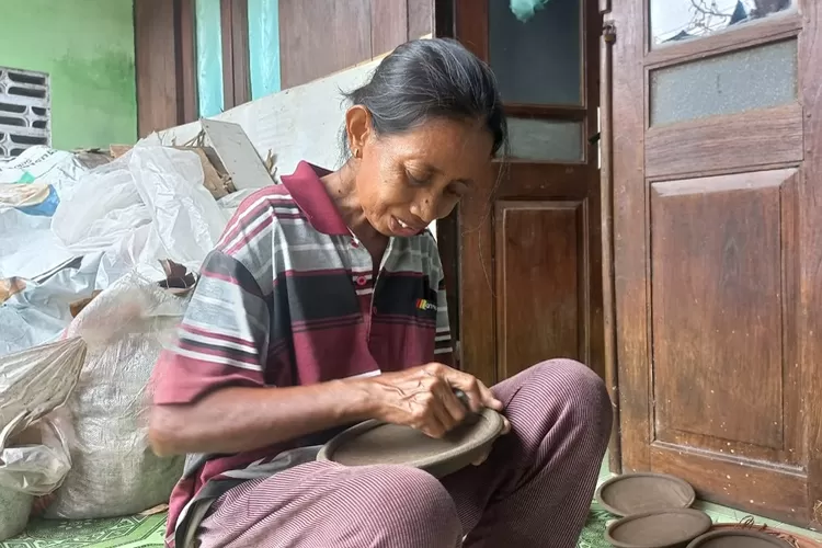 Sumini, pengrajin cobek di kendalsedang melakukan aktifitas membuat cobek di depan rumah.  (edi prayitno/kontributor kendal)