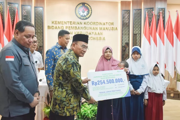 Menko PMK, Muhadjir Effendy bersama Direktur Utama BPJS Ketenagakerjaan, Anggoro Eko Cahyo menyerahkan santunan kepada keluarga KPPS asal Kendal yang meninggal saat bertugas.  (dokumen Kominfo)